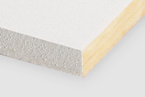 A close-up of the corner of a rectangular white plasterboard panel showing its smooth top surface and layered cross-section with a dense gypsum core and paper backing.